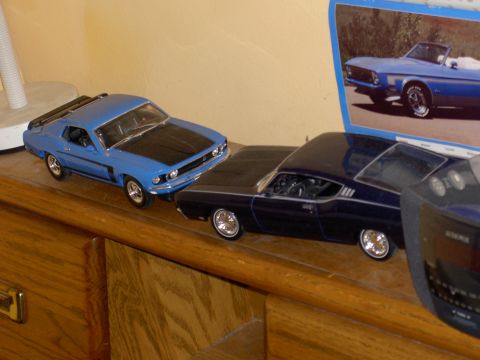 1988 Ford Bronco - Model cars displayed on a shelf, with a picture of a classic convertible in the background.