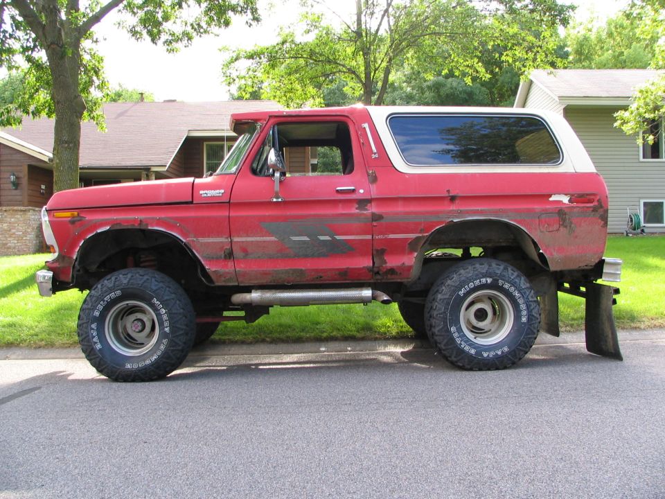 Red 1978 Ford Bronco side view, lifted with off-road tires