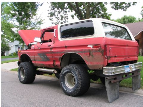 1978 Ford Bronco - This 1978 Ford Bronco is parked on a street with its hood up, showing signs of wear and tear.