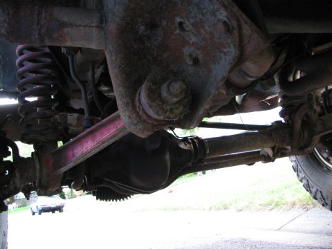 1978 Ford Bronco - Close-up view of the undercarriage, showing suspension components and the differential. The Supermotors.net logo is present in the lower ri…