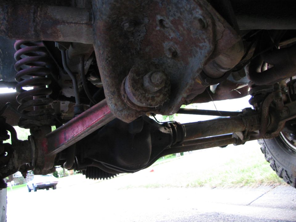 Undercarriage view of a vehicle's suspension and differential. Supermotors.net logo visible