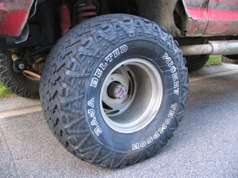 1978 Ford Bronco - Close-up of a Mickey Thompson Baja Belted tire on a vehicle's suspension and exhaust system.
