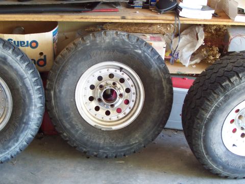1991 Ford Bronco - Close-up of three off-road tires and rims, with visible text on the tires.
