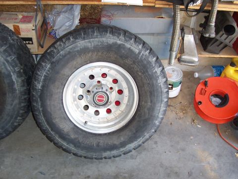 1991 Ford Bronco - A single wheel and tire, possibly from a 1991 Ford Bronco, is shown with various items in the background.