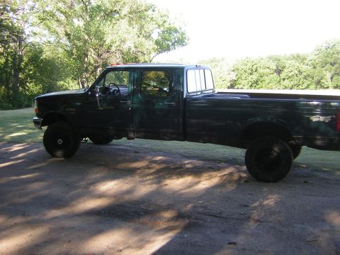 1996 Ford F-350 - Side profile of a green 1996 Ford F-350 crew cab pickup truck parked outdoors.