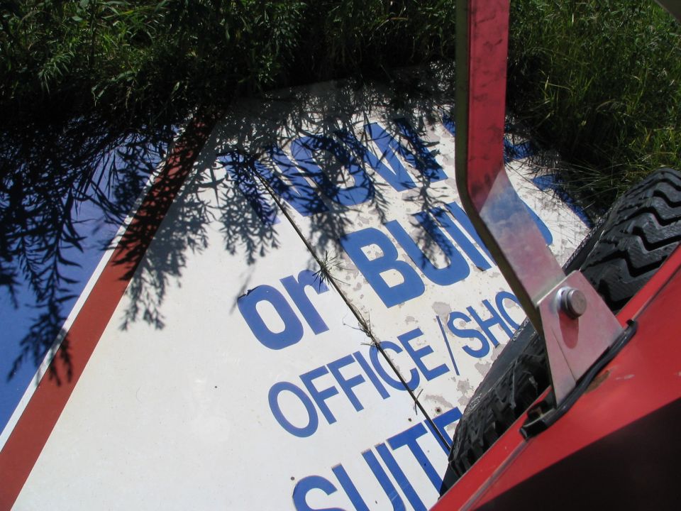 Sign with blue text 'or BUILD OFFICE/SUITES' on white surface, with red trim