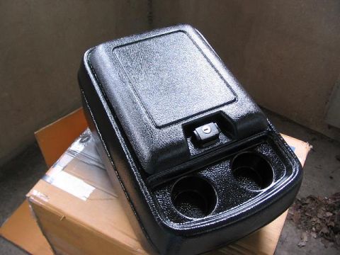 1991 Ford Bronco - A black plastic center console unit with cup holders sits on top of a cardboard box.