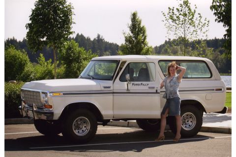 1976 Ford F-150 - A white 1978 Ford Bronco is parked outdoors with a woman posing beside it.