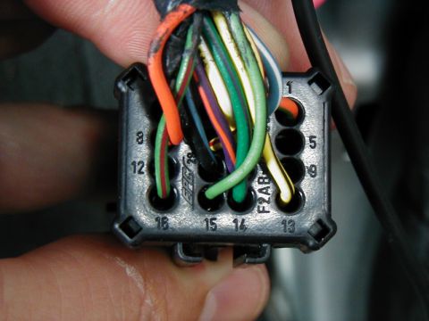 2002 Ford Excursion - A hand holds a multi-pin electrical connector with many wires, showing part numbers and wire colors.