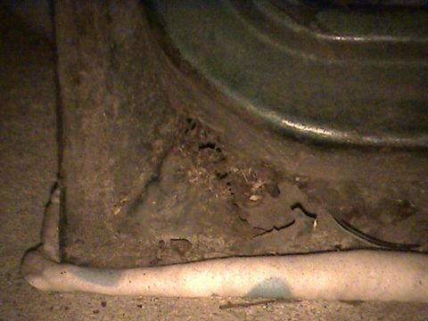 1978 Ford Bronco - Detail of corroded metal, likely from a vehicle's undercarriage, with visible damage and texture.