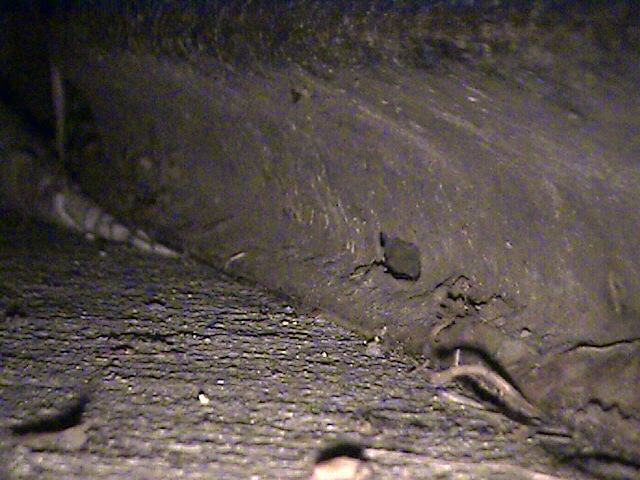 Underside of a vehicle, showing frame and road debris
