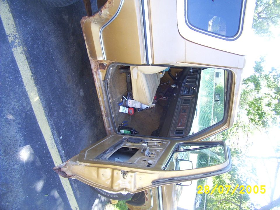 1979 Ford Bronco interior showing removed door, tan seats, and dashboard