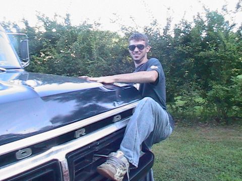 1977 Ford F-250 - A man poses on the front grille and hood of a 1977 Ford F-250 pickup truck.