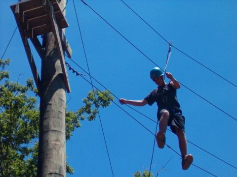 1995 Ford Bronco - A person is suspended mid-air on a zip line, attached to a cable system.