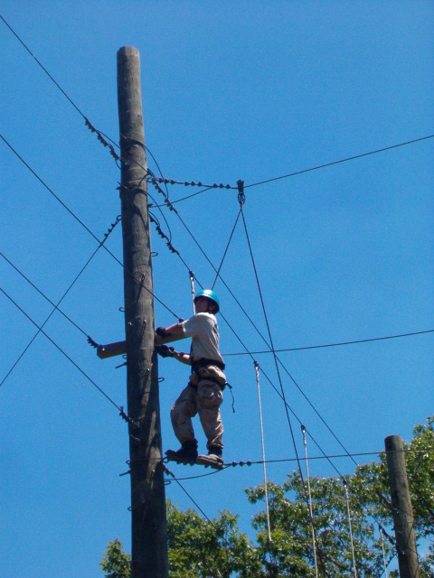 1995 Ford Bronco - A worker is suspended by safety lines while performing maintenance on utility poles and wires.
