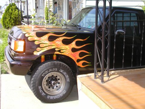 1991 Ford F-150 - This 1991 Ford F-150 features custom flame graphics on its dark brown paint.
