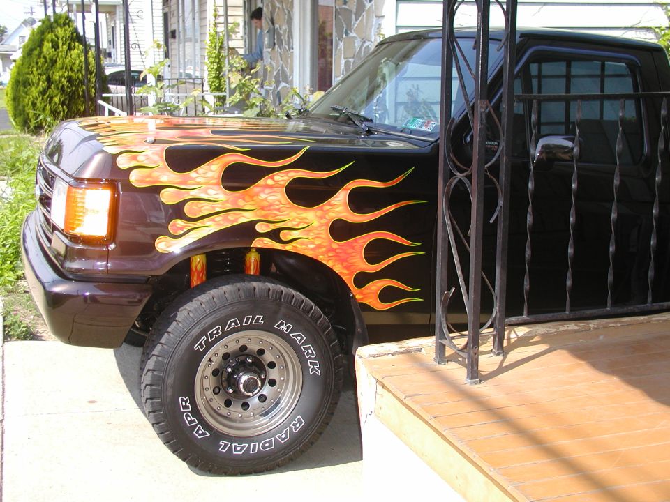 1991 Ford F-150 truck with custom flame graphics on the front fender and hood