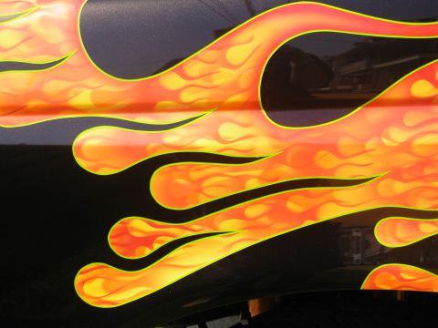 1991 Ford F-150 - Custom flame paint job adorns the side of a dark vehicle, with visible text at the bottom reading 'SUPERMOTORS'.