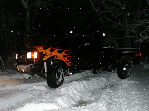 1991 Ford F-150 - Truck with flame decals is stuck in the snow at night.