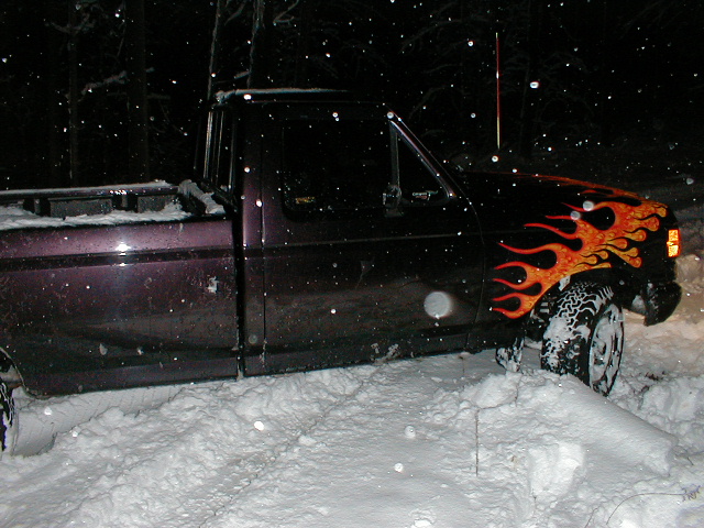 1991 Ford F-150 with flame decals stuck in snow