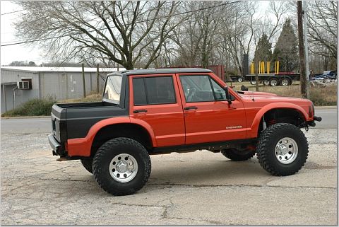 1986 Ford Bronco - Modified Jeep Comanche pickup truck with lifted suspension and custom bed.