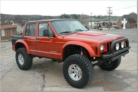 1986 Ford Bronco - This modified Jeep Cherokee features a custom front bumper with auxiliary lights and large off-road tires.