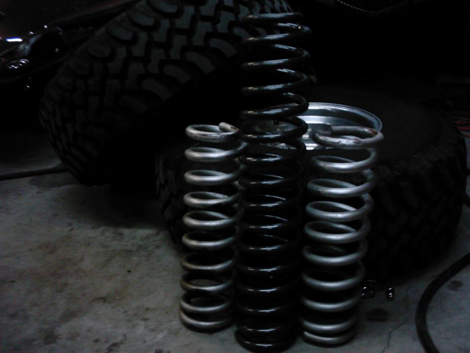 Three coil springs next to a large tire. Supermotors.net logo visible