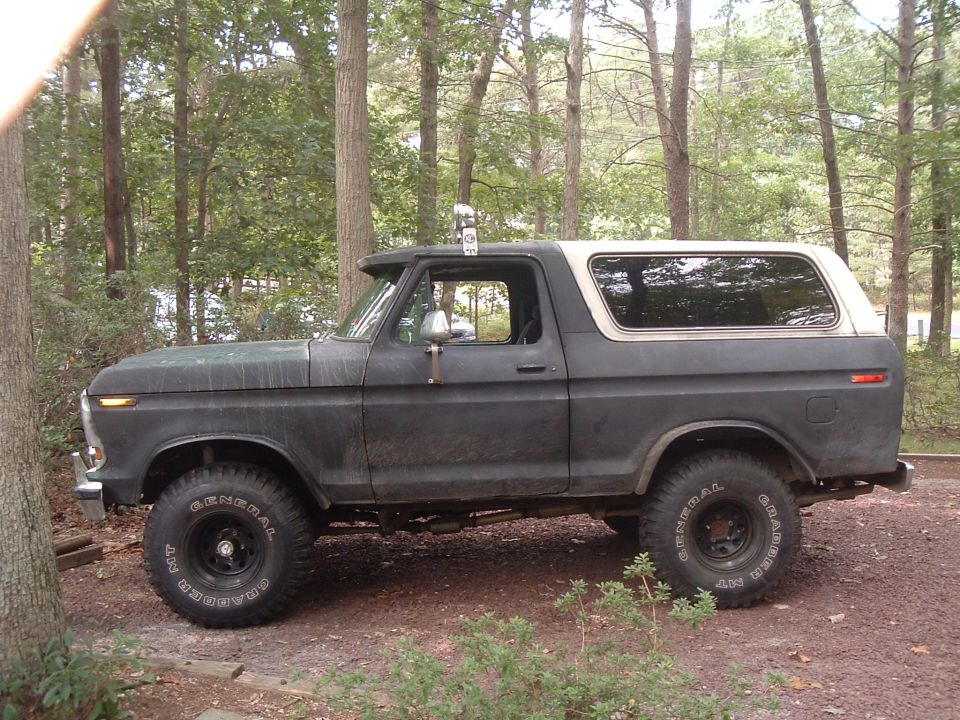 Dark green 1978 Ford Bronco with a white hardtop, seen from the side