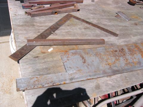 1991 Ford Explorer - Metal stock and tools are laid out on a weathered wooden workbench, ready for fabrication.