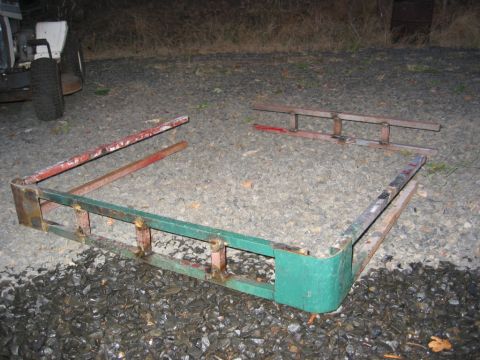 1991 Ford Explorer - Disassembled roof rack parts are scattered on a gravel surface, with a partial view of a white vehicle behind.
