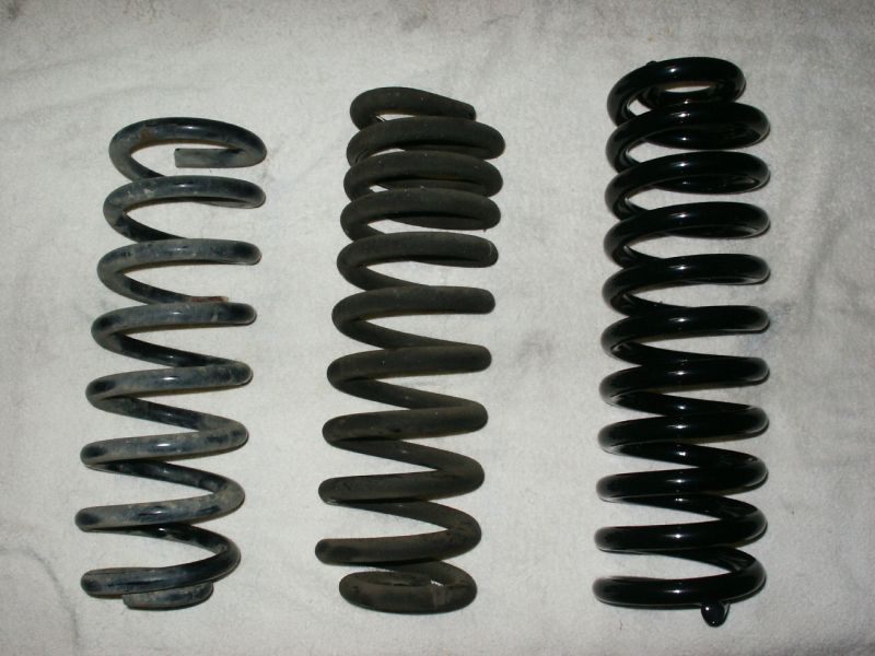 Three suspension coil springs, one small gray, one medium black, one large black