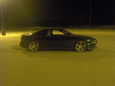 1994 Ford Probe - A dark green 1994 Ford Probe is parked in a lot at night, illuminated by artificial lighting.