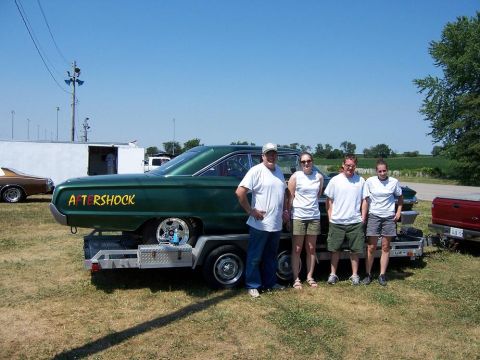 1964 Ford Galaxie - A group poses with a custom green car, identified as a 1963 model, displayed on a trailer.