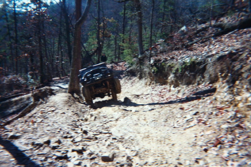 Off-road vehicle on a rocky, wooded trail