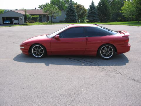 1994 Ford Probe - Side profile of a red 1994 Ford Probe coupe with aftermarket wheels.