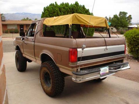 1989 Ford Bronco - This 1989 Ford Bronco features a tan soft top and appears to have a lifted suspension.