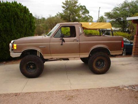 1989 Ford Bronco - This lifted 1989 Ford Bronco features a removable yellow soft top, offering a unique look.