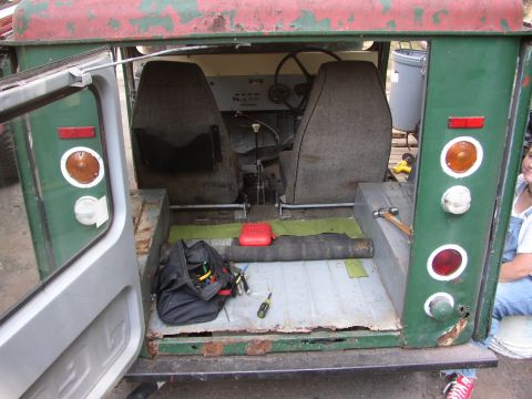 1973 Jeep CJ5 - The interior of a 1973 Jeep CJ5 shows two seats, a steering wheel, and tools on the floor.