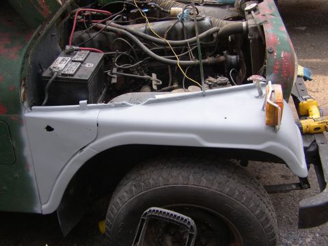 1973 Jeep CJ5 - The front fender and engine bay of a 1973 Jeep CJ5 are shown, with the hood open.