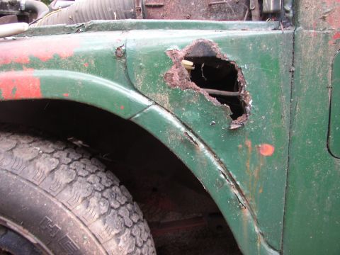 1973 Jeep CJ5 - The fender of this vehicle shows significant rust and damage, with a large hole exposing the interior.