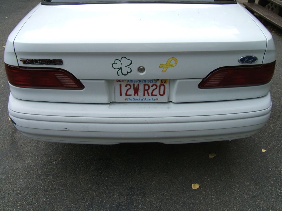 Rear of a white 1998 Ford Taurus with a Taurus badge and Massachusetts license plate