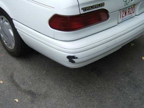 1998 Ford Taurus - Rear view of a 1998 Ford Taurus showing damage to the bumper and a taillight.
