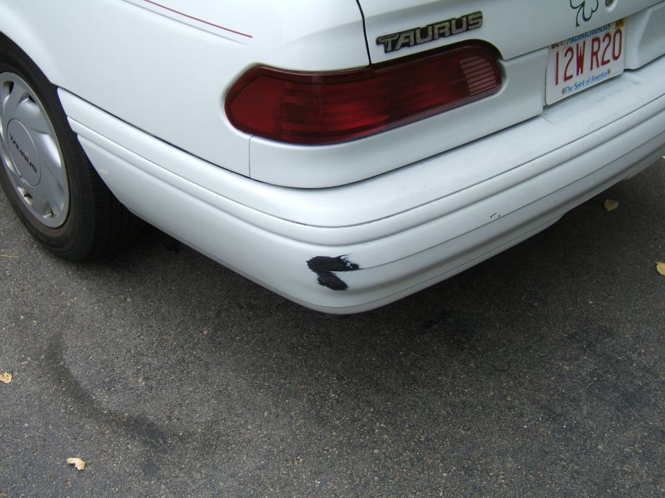 1998 Ford Taurus rear bumper with scuff marks and a red taillight
