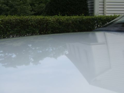 1998 Ford Taurus - The reflection of a house is visible on the hood of a white car.