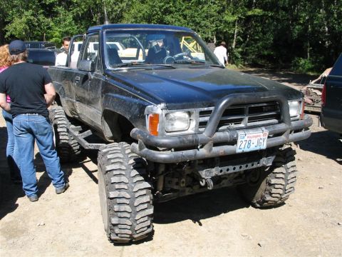1989 Dodge Power Ram - Modified Toyota pickup truck with oversized tires and custom bumper, parked outdoors.