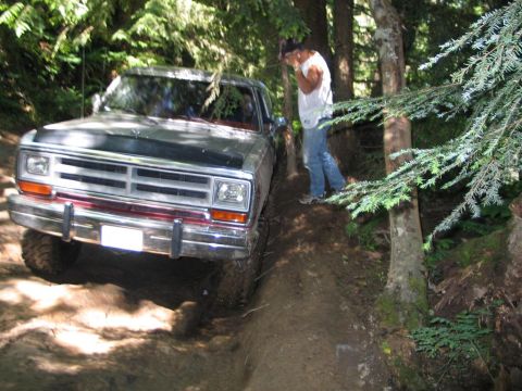 1989 Dodge Power Ram - A 1989 Dodge Power Ram navigates a challenging off-road trail with a person observing.