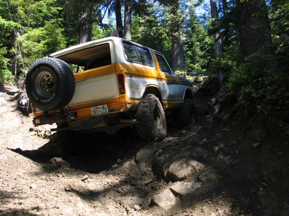 Ford Bronco on a rocky trail, spare tire mounted on the back