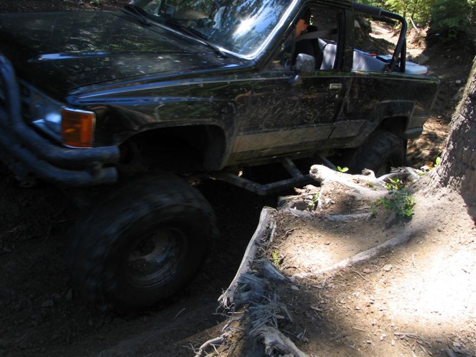 Black off-road truck with large tires on a dirt trail