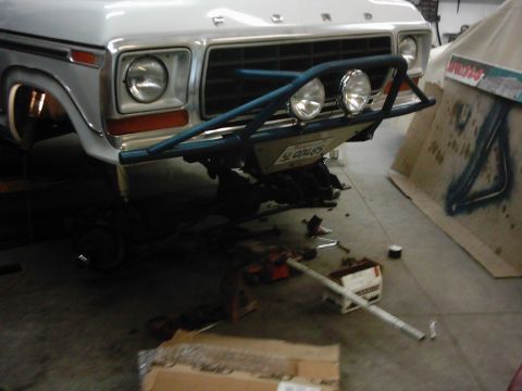 1978 Ford Bronco - Front view of a 1978 Ford Bronco with a custom bumper and lights, parked in a garage.