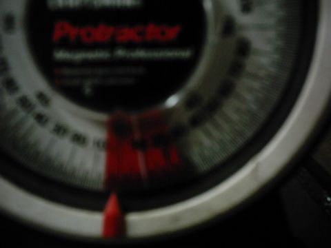 1978 Ford Bronco - Close-up of a gauge with a red needle and markings, showing the word 'Protractor'.